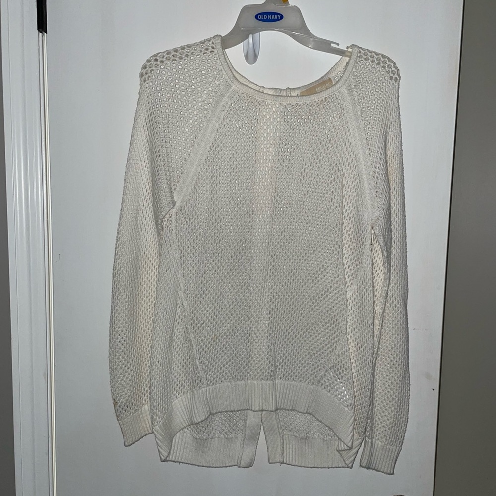 Michael Kor’s white sweater with gold buttons down the back